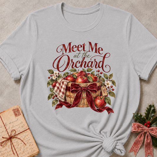 Athletic Heather relaxed fit tee with Meet Me at the Orchard lettering, a harvest basket of red apples, blossoms and a burgundy bow