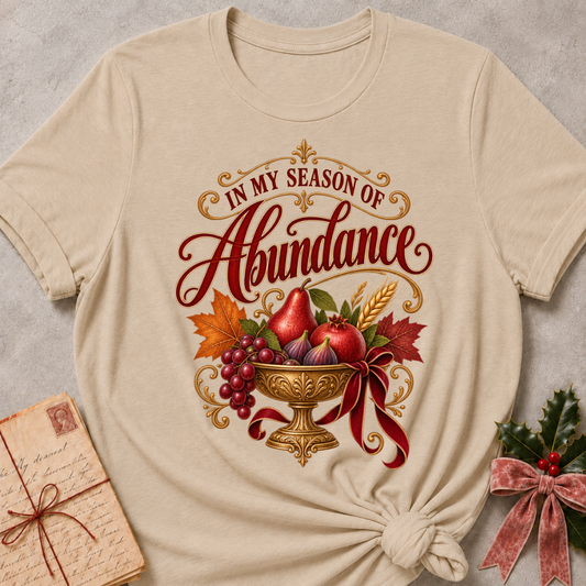 Forest Green relaxed fit tee with In My Season of Abundance script and an ornate golden bowl of pears, pomegranates, figs, grapes and wheat with a ruby bow