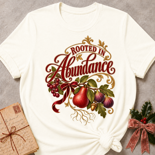 Heather Deep Teal relaxed fit tee with Rooted in Abundance script, pears, figs, grapes and an acorn on golden roots with a deep red bow