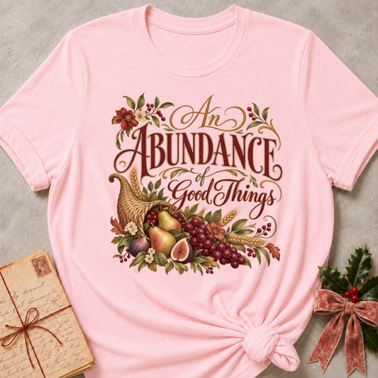 Pink relaxed fit tee with An Abundance of Good Things script and a woven cornucopia of pears, grapes, figs, wheat and autumn flowers