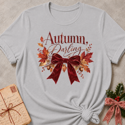 Autumn, Darling script with a burgundy velvet bow, golden acorns, and falling leaves on a heathered grey relaxed fit tee