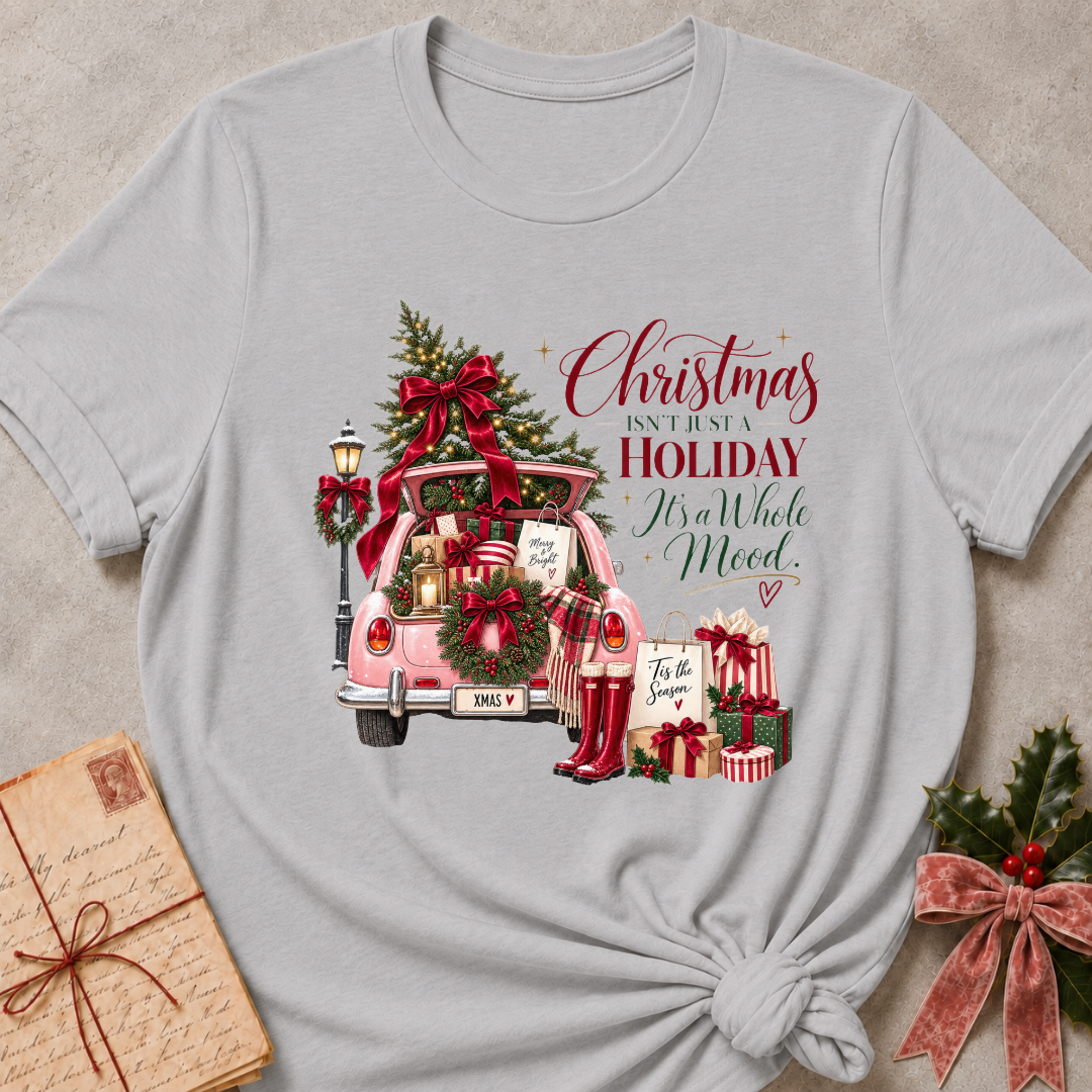 Athletic heather grey relaxed fit tee with a pink Christmas truck full of gifts and Christmas Isn't Just A Holiday It's A Whole Mood lettering