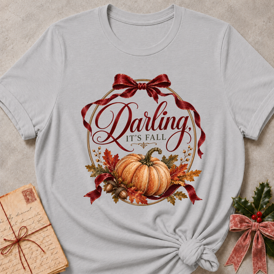 Athletic heather grey women's relaxed tee with a vintage Darling It's Fall script design framed by a gold wreath, a burgundy ribbon bow, and a harvest pumpkin