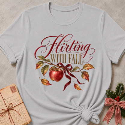 Athletic heather grey women's relaxed tee with Flirting With Fall script above a red apple on a leafy branch tied with a burgundy ribbon
