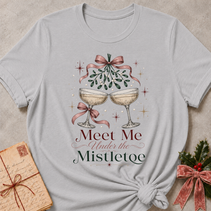 Athletic Heather relaxed fit tee with Meet Me Under the Mistletoe lettering, two champagne coupes, blush bows and a sprig of mistletoe