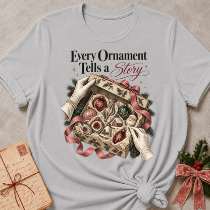 Athletic Heather relaxed fit tee with Every Ornament Tells a Story lettering, gloved hands lifting the lid on a keepsake box of vintage ornaments