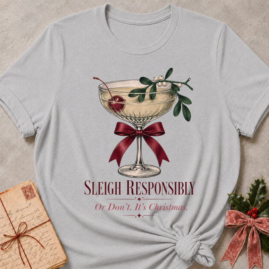Athletic Heather relaxed fit tee with Sleigh Responsibly lettering, a vintage champagne coupe with a cherry, mistletoe and a burgundy bow