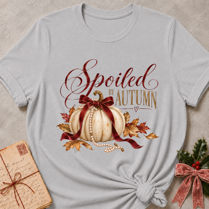 Athletic heather grey women's relaxed tee with Spoiled by Autumn script over a cream pumpkin tied in a burgundy velvet bow, pearls, and fall leaves