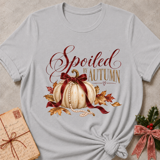 Athletic heather grey women's relaxed tee with Spoiled by Autumn script over a cream pumpkin tied in a burgundy velvet bow, pearls, and fall leaves