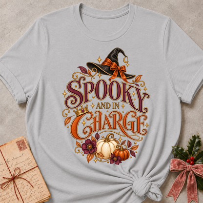 Athletic Heather Spooky and In Charge tee with a bow tied witch's hat, gold crown, white pumpkins and plum blooms