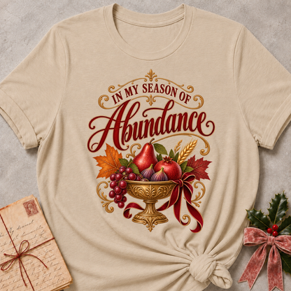 Forest Green relaxed fit tee with In My Season of Abundance script and an ornate golden bowl of pears, pomegranates, figs, grapes and wheat with a ruby bow