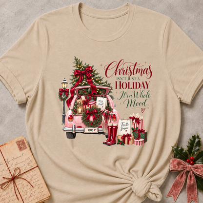 Heather stone relaxed fit tee with a pink Christmas truck full of gifts and Christmas Isn't Just A Holiday It's A Whole Mood lettering