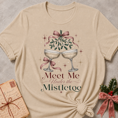 Heather Stone relaxed fit tee with Meet Me Under the Mistletoe lettering, two champagne coupes, blush bows and a sprig of mistletoe