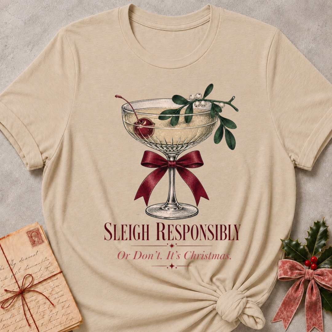 Heather Stone relaxed fit tee with Sleigh Responsibly lettering, a vintage champagne coupe with a cherry, mistletoe and a burgundy bow