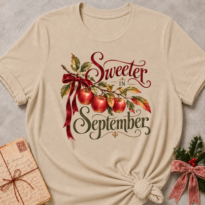 Heather Stone relaxed fit tee with Sweeter in September script lettering, an apple branch with red apples, autumn leaves and a burgundy bow
