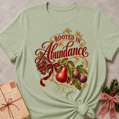 Maroon relaxed fit tee with Rooted in Abundance script, pears, figs, grapes and an acorn on golden roots with a deep red bow