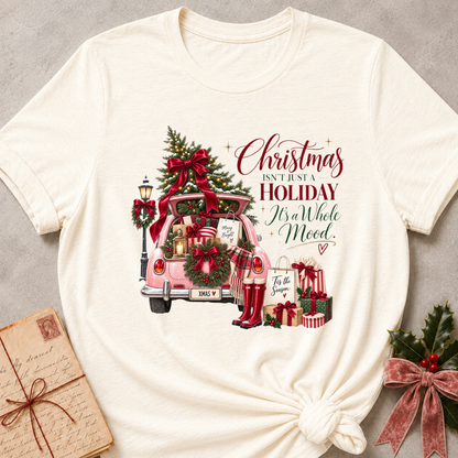 Natural cream relaxed fit tee with a pink Christmas truck full of gifts and Christmas Isn't Just A Holiday It's A Whole Mood lettering