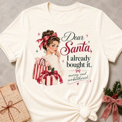 Natural relaxed fit tee with Dear Santa, I already bought it lettering, a vintage holiday shopper with striped gift boxes and red bows