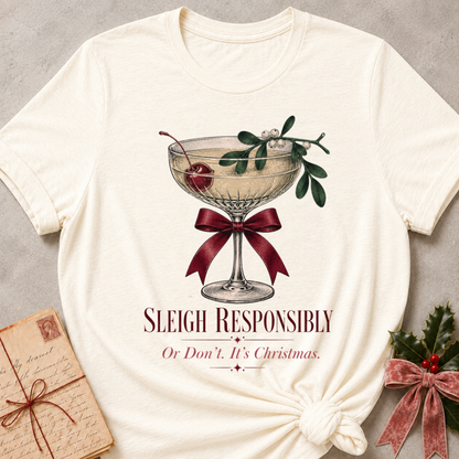 Natural relaxed fit tee with Sleigh Responsibly lettering, a vintage champagne coupe with a cherry, mistletoe and a burgundy bow