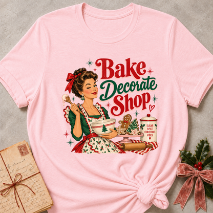 Soft pink relaxed fit tee with a winking retro baker and Bake Decorate Shop lettering