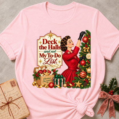 Pink relaxed fit tee with Deck the Halls and not My To-Do List lettering, a vintage woman in red trimming an ornament-covered tree