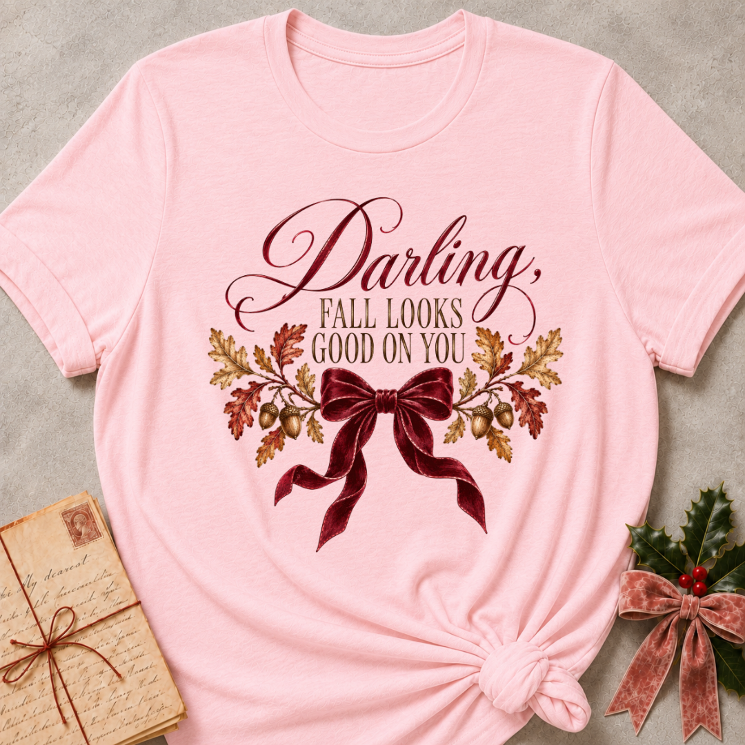 Pink women's relaxed tee with a Darling, Fall Looks Good On You script design with a burgundy velvet bow, oak leaves, and acorns