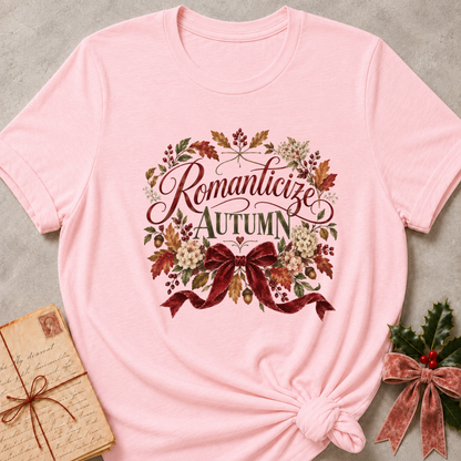 Pink relaxed fit tee with Romanticize Autumn script lettering, autumn leaves, cream blooms and a burgundy velvet bow