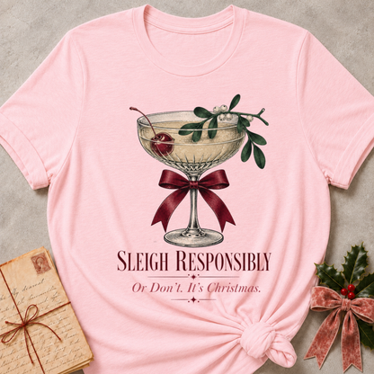 Pink relaxed fit tee with Sleigh Responsibly lettering, a vintage champagne coupe with a cherry, mistletoe and a burgundy bow