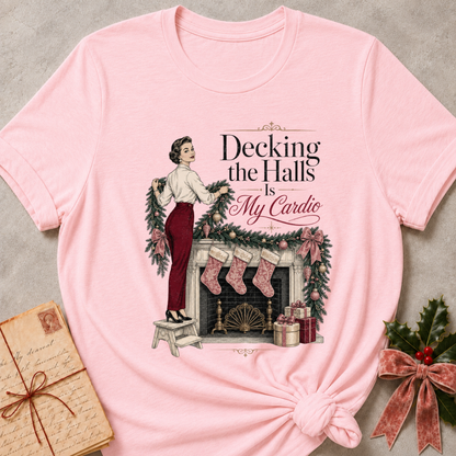 Pink relaxed fit tee with Decking the Halls Is My Cardio lettering, a vintage woman hanging garland above a mantel of stockings, bows and gifts
