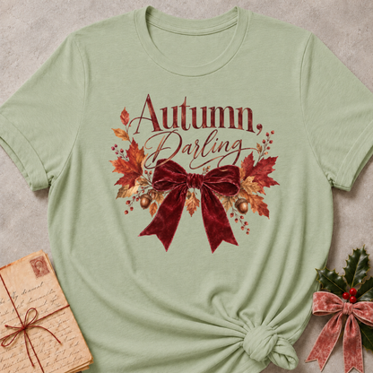 Autumn, Darling script with a burgundy velvet bow, golden acorns, and falling leaves on a soft sage relaxed fit tee