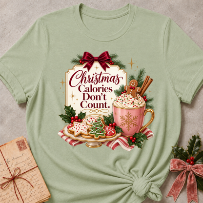 Sage relaxed fit tee with Christmas Calories Don't Count lettering, frosted cookies, a cocoa mug with a gingerbread man and a burgundy bow
