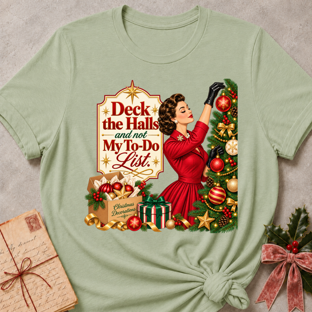 Sage relaxed fit tee with Deck the Halls and not My To-Do List lettering, a vintage woman in red trimming an ornament-covered tree