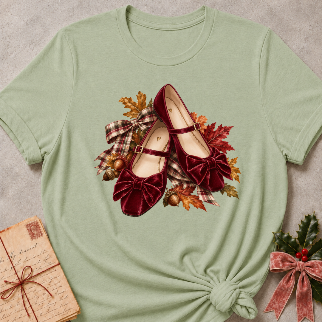 Sage relaxed fit tee with a row of autumn boots, falling leaves and a bow