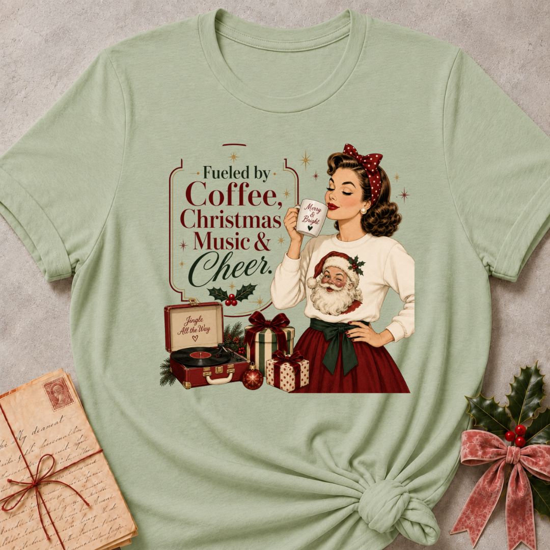 Sage green relaxed fit tee with a retro Christmas pinup and Fueled By Coffee Christmas Music and Cheer lettering
