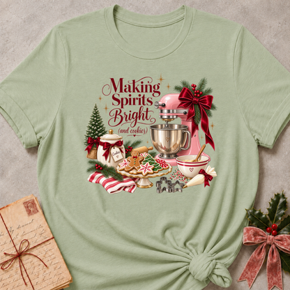 Sage green relaxed fit tee with a vintage Christmas baking scene and Making Spirits Bright lettering