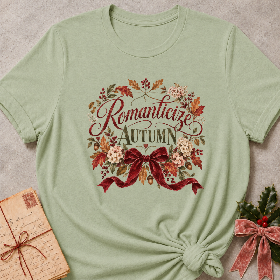 Sage relaxed fit tee with Romanticize Autumn script lettering, autumn leaves, cream blooms and a burgundy velvet bow