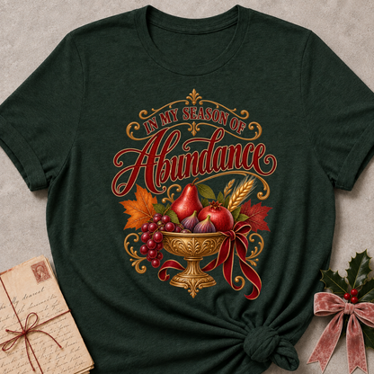Sage relaxed fit tee with In My Season of Abundance script and an ornate golden bowl of pears, pomegranates, figs, grapes and wheat with a ruby bow