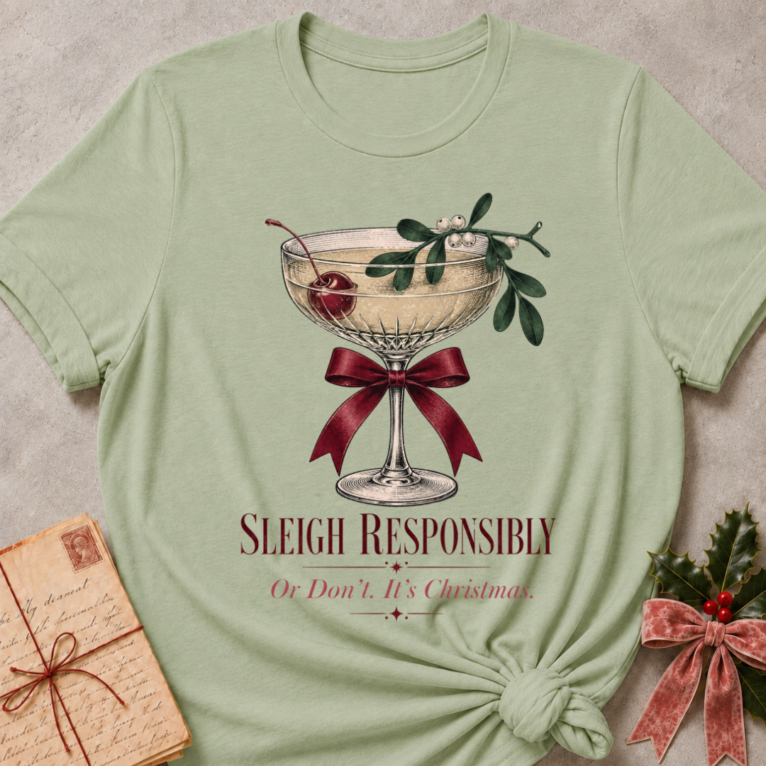 Sage relaxed fit tee with Sleigh Responsibly lettering, a vintage champagne coupe with a cherry, mistletoe and a burgundy bow