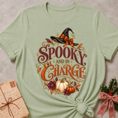 Sage Spooky and In Charge tee with a bow tied witch's hat, gold crown, white pumpkins and plum blooms