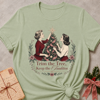 Sage green relaxed fit tee with two vintage women trimming a Christmas tree and Trim the Tree Keep the Tradition lettering