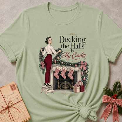 Sage relaxed fit tee with Decking the Halls Is My Cardio lettering, a vintage woman hanging garland above a mantel of stockings, bows and gifts