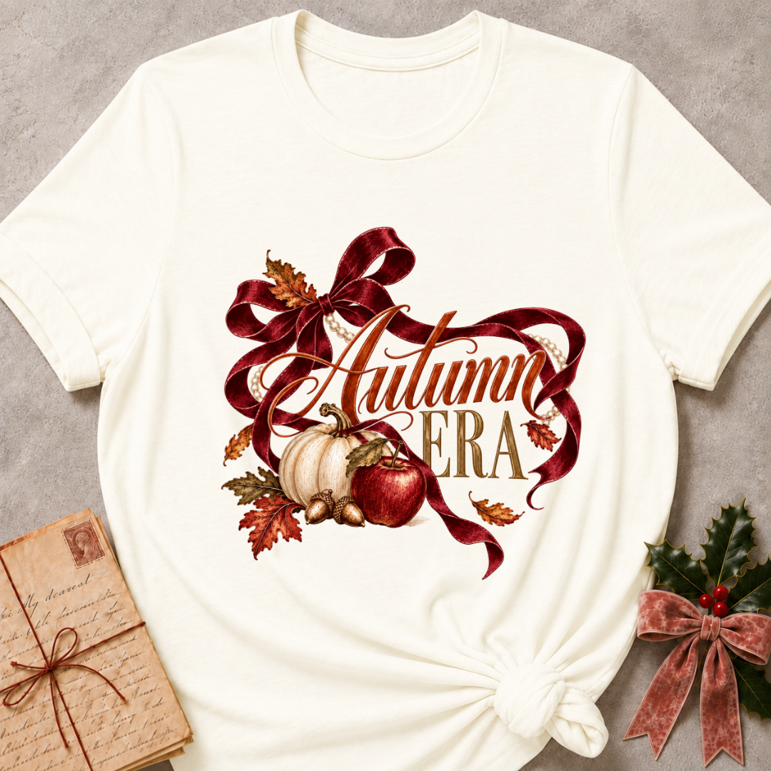 Vintage white women's relaxed tee with Autumn Era script framed by a burgundy ribbon, pearls, a cream pumpkin, a red apple, and fall leaves