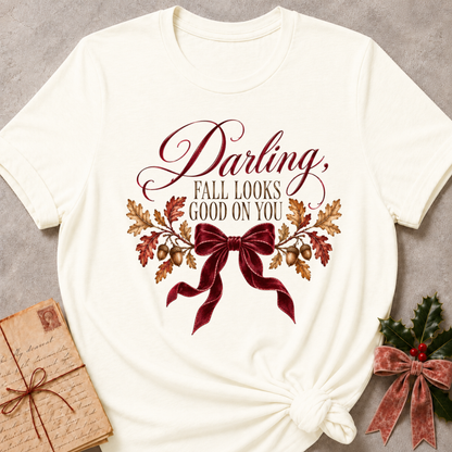 Vintage white women's relaxed tee with a Darling, Fall Looks Good On You script design with a burgundy velvet bow, oak leaves, and acorns