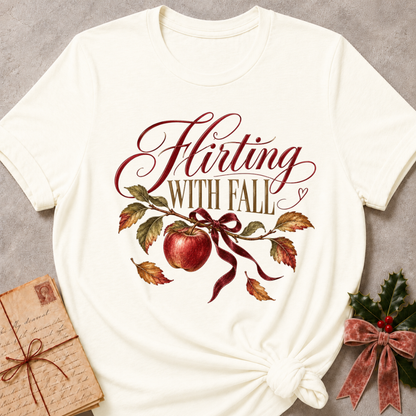 Vintage white women's relaxed tee with Flirting With Fall script above a red apple on a leafy branch tied with a burgundy ribbon