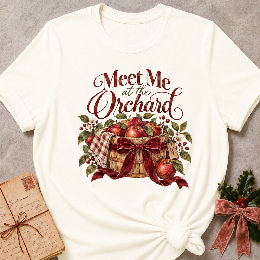 Vintage White relaxed fit tee with Meet Me at the Orchard lettering, a harvest basket of red apples, blossoms and a burgundy bow