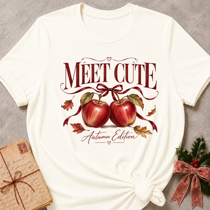Vintage White relaxed fit tee with Meet Cute Autumn Edition lettering, two red apples and a burgundy bow