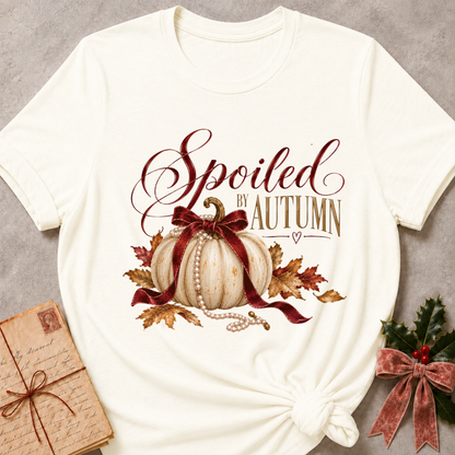 Vintage white women's relaxed tee with Spoiled by Autumn script over a cream pumpkin tied in a burgundy velvet bow, pearls, and fall leaves